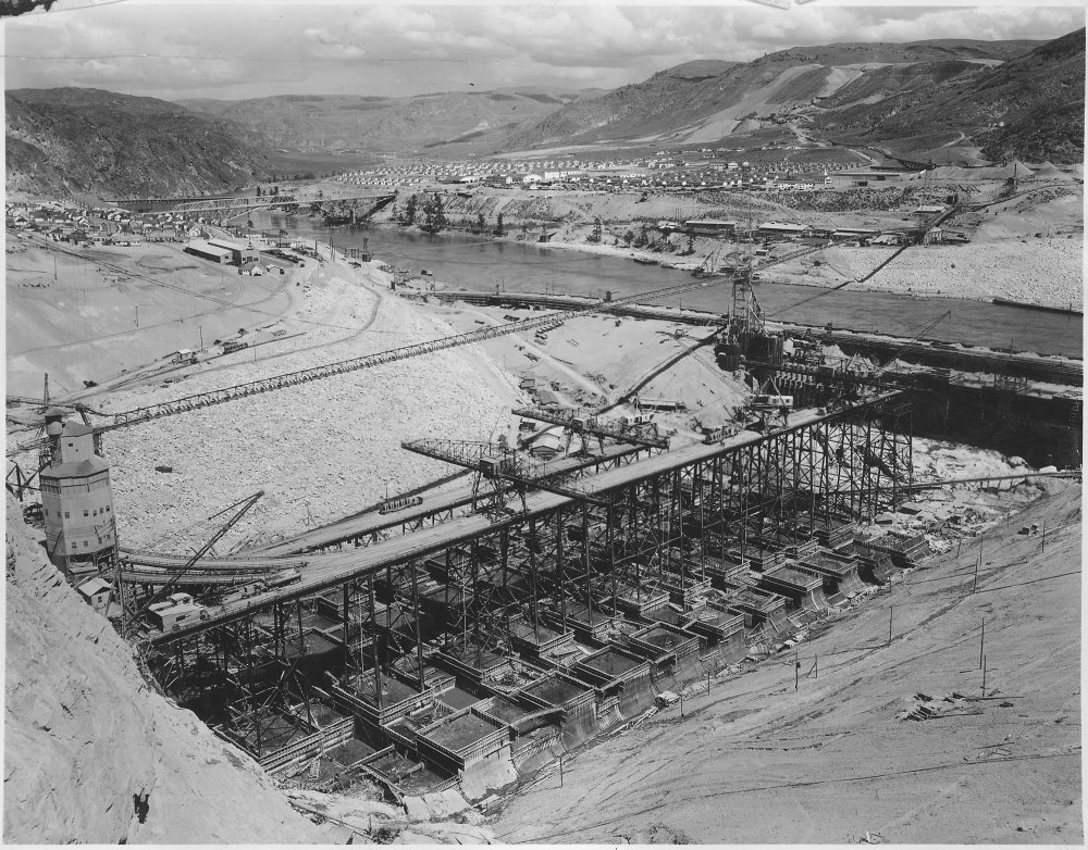 _View_looking_north_across_the_west_dam_and_power-house_area_showing_Westmix_concrete_plant,_placing_trestles_and..._-_NARA_-_294320.jpg